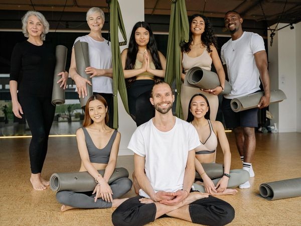 Diverse group of people smiling during a yoga class.